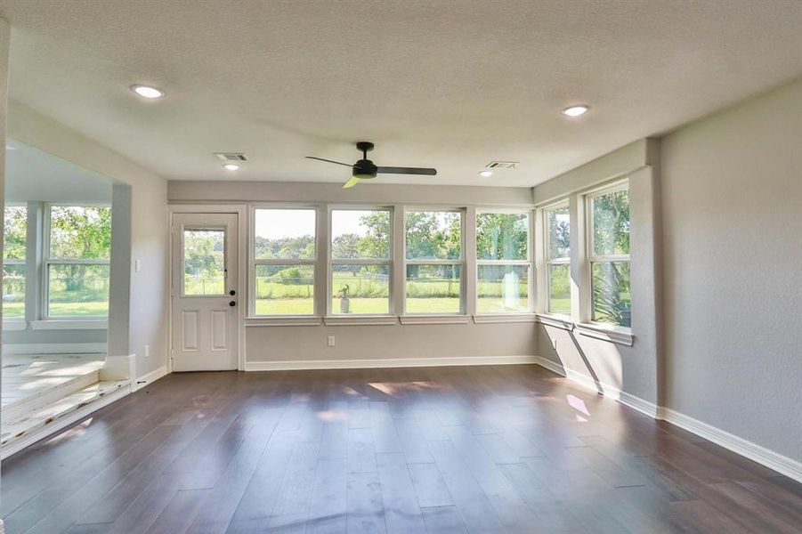 Picturesque Wall-of-Windows Offers Country Serenity! Stunning "Bruce Dogwood" engineered wood flooring in the family room with recessed canned lights and dual ceiling fans.