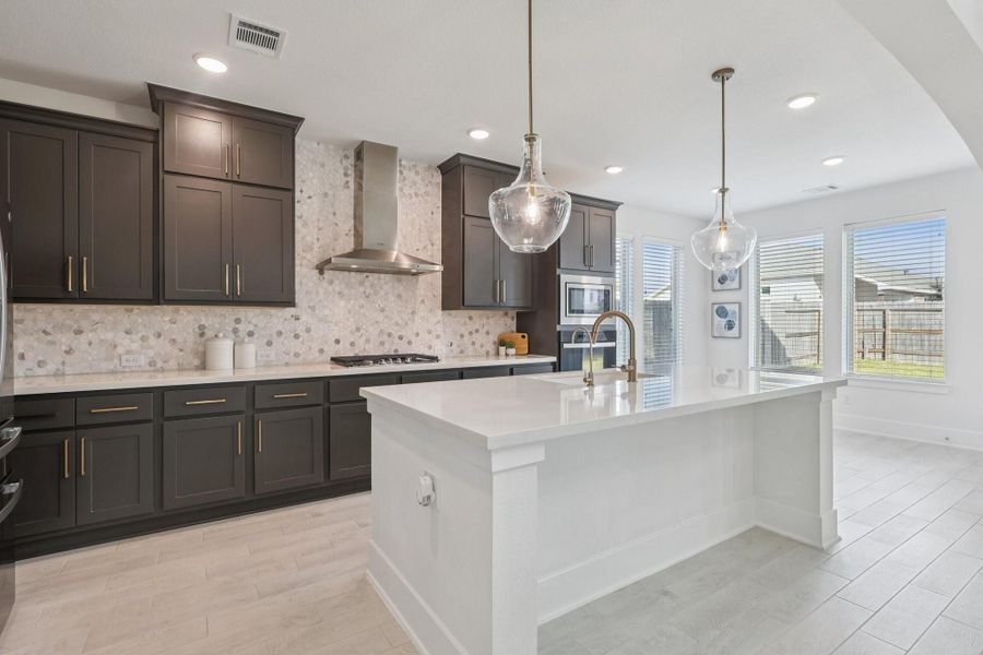 Gorgeous kitchen with gold accents and upgraded back splash.