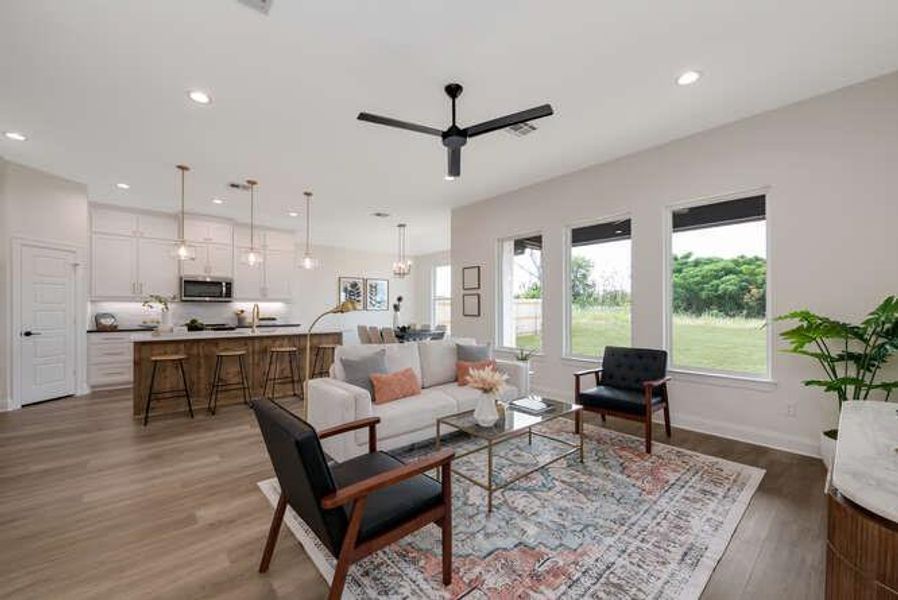 Living room featuring recessed lighting, dark wood-type flooring, ceiling fan, and a chandelier Living room featuring recessed lighting, dark wood-type flooring, ceiling fan, and a chandelier