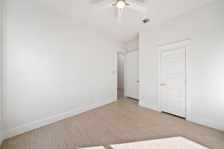 Unfurnished bedroom with wood tiled floors, ceiling fan, and a closet