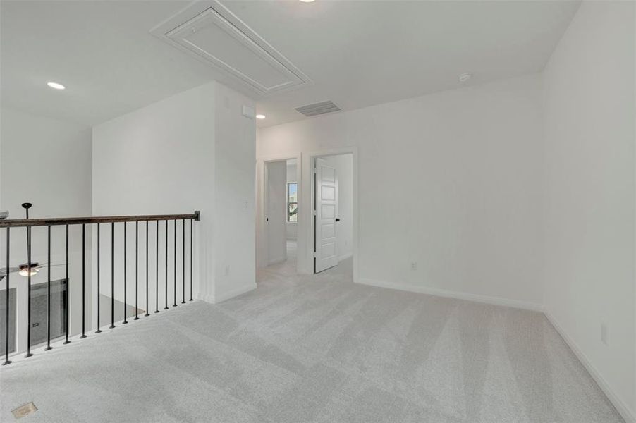 Open loft area featuring light gray carpeting and recessed lighting