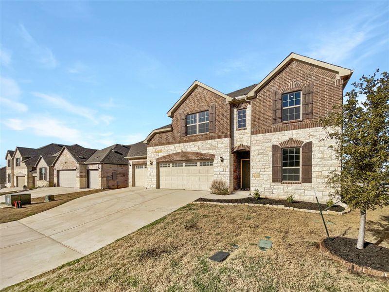 View of front of house featuring a garage, brick siding, and driveway