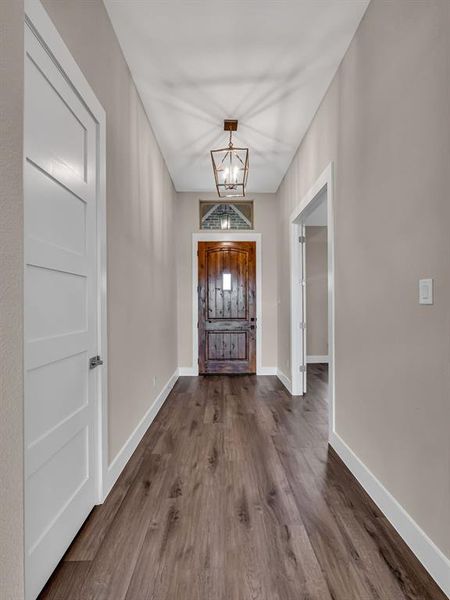 Entrance foyer with a notable chandelier and hardwood / wood-style flooring