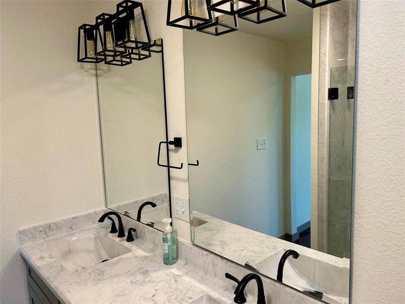 Bathroom with double vanity and a textured wall