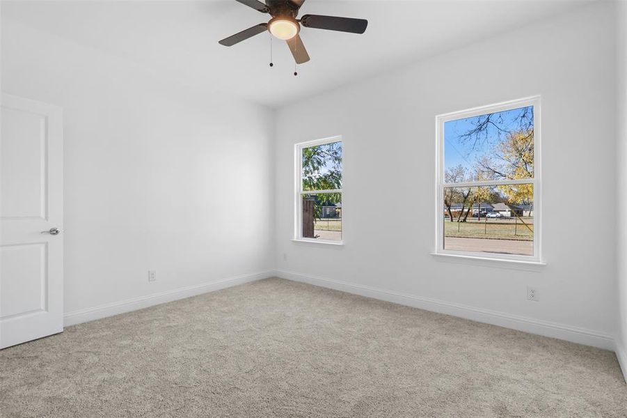 Carpeted empty room with ceiling fan