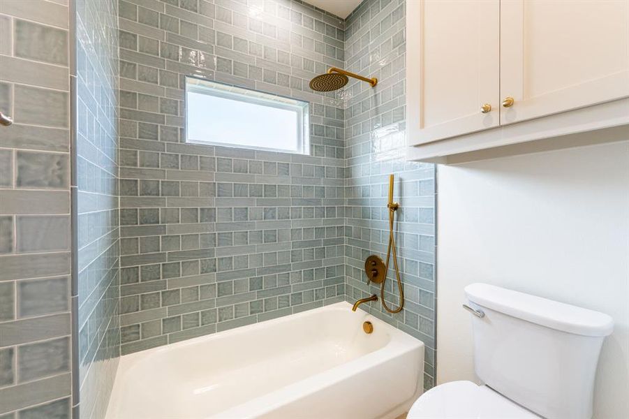 Bathtub with full wall-to-ceiling subway tile surround, rain showerhead, and handheld shower sprayer Bathtub with full wall-to-ceiling subway tile surround, rain showerhead, and handheld shower sprayer