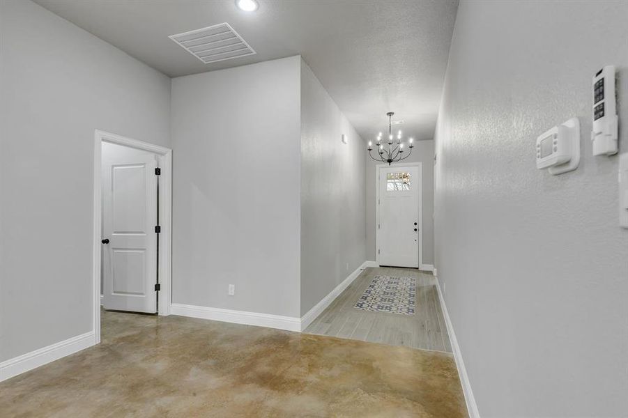 Corridor with a chandelier and baseboards