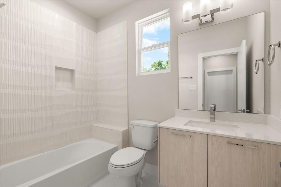 Modern full bath shared by the secondary bedrooms, featuring a floating vanity, large framed mirror & sleek tile surround for a bright, contemporary feel.