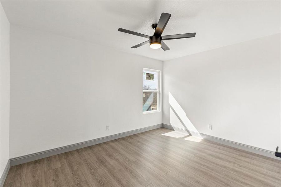 Unfurnished room with light wood finished floors and a ceiling fan