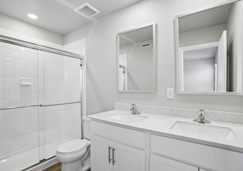 The master bathroom has a dual sink vanity and a step in shower.
