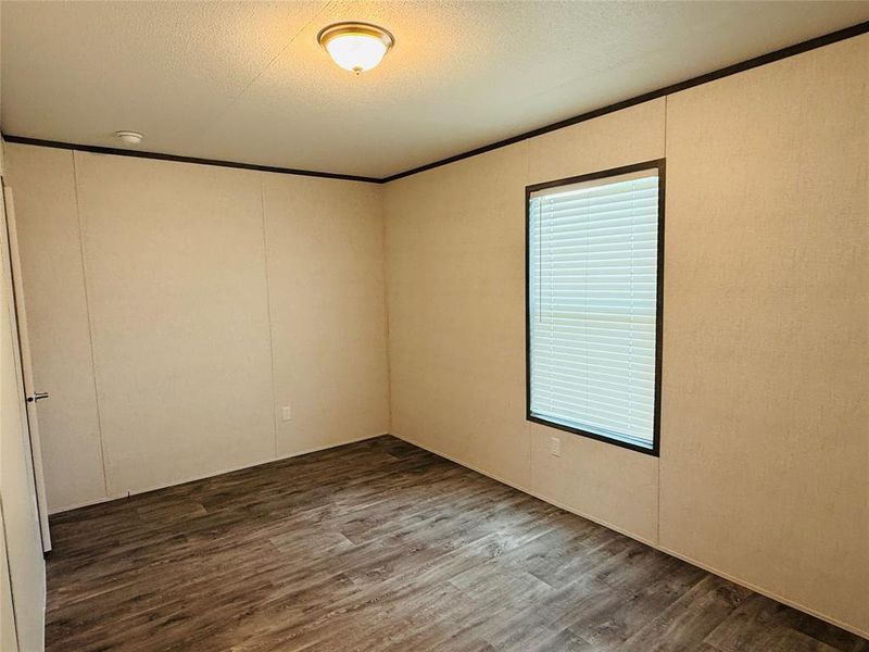 Unfurnished room featuring dark wood-style floors and a textured ceiling