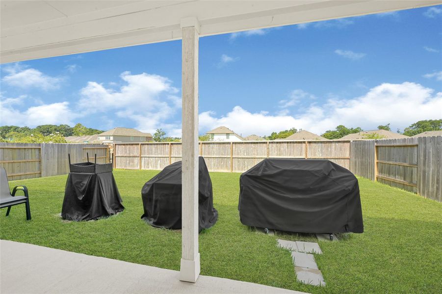 Spacious fenced backyard with a covered patio, perfect for outdoor gatherings and relaxation. Spacious fenced backyard with a covered patio, perfect for outdoor gatherings and relaxation.
