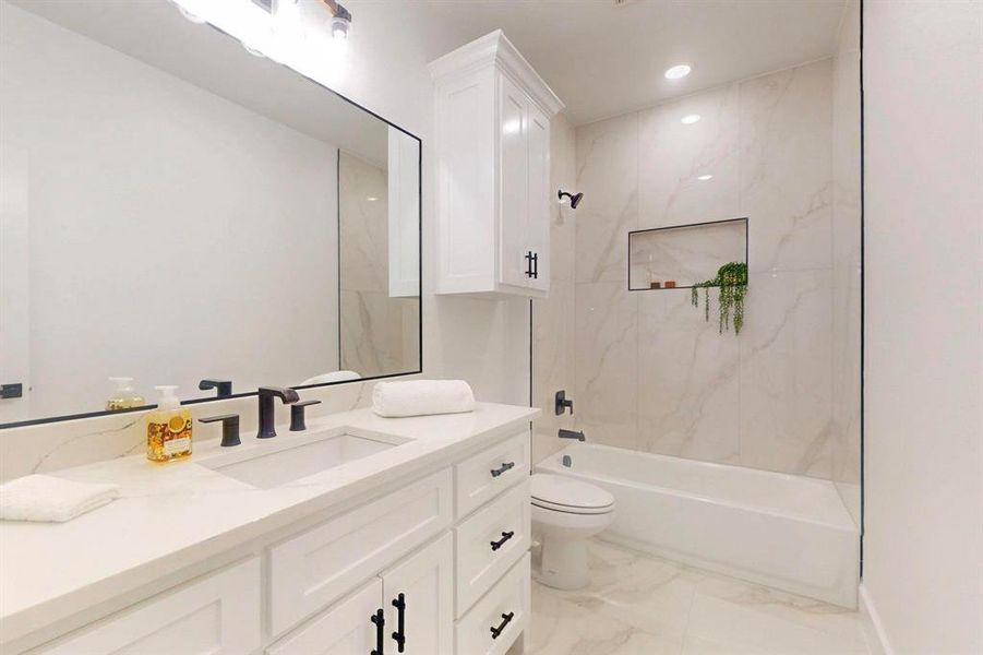 Full bathroom with shower / bath combination, light marble finish flooring, vanity, and recessed lighting Full bathroom with shower / bath combination, light marble finish flooring, vanity, and recessed lighting