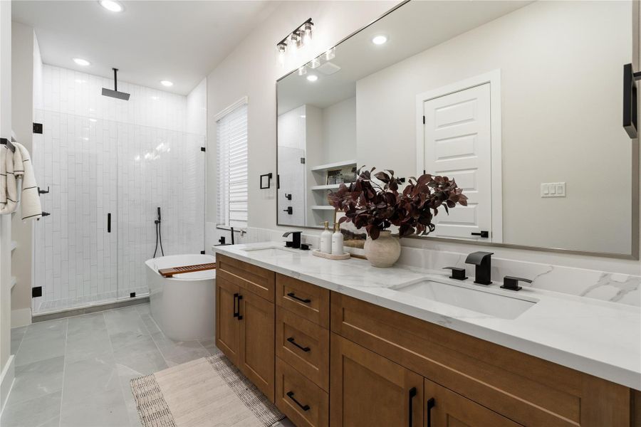 A well-appointed primary bath featuring a frameless walk-in shower, a freestanding tub, and an expansive dual-sink vanity. Generous counter space and soft-close cabinetry add both functionality and a refined finish. A well-appointed primary bath featuring a frameless walk-in shower, a freestanding tub, and an expansive dual-sink vanity. Generous counter space and soft-close cabinetry add both functionality and a refined finish.