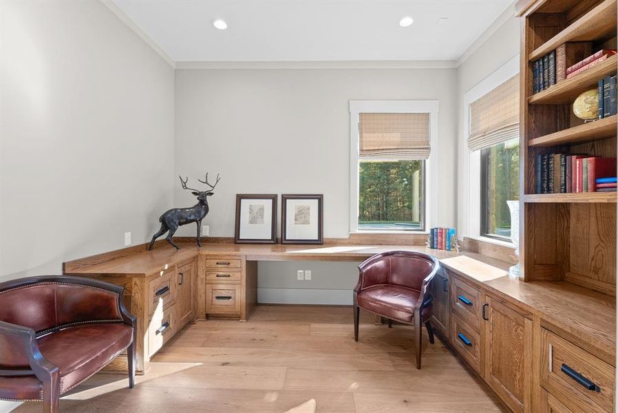 Sitting room featuring built in desk, light wood finished floors, ornamental molding, and recessed lighting