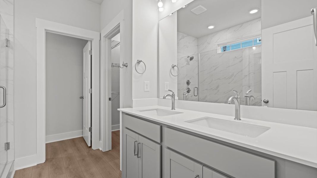 Superior en-suite primary bathroom with stylish dual vanity and tiled walk-in shower crafted with high standards in mind