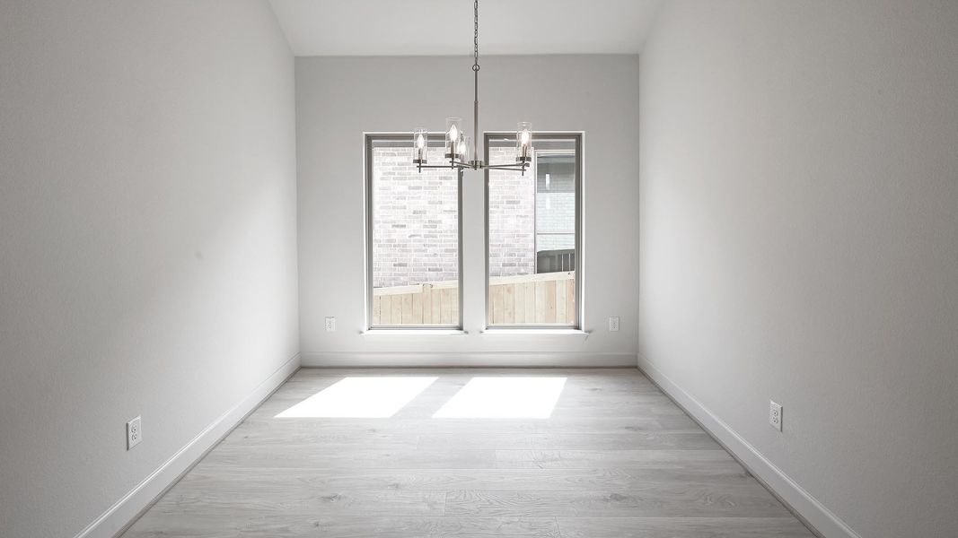 Unfurnished dining area featuring light wood finished floors and a chandelier