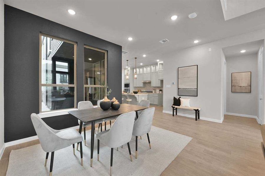 Spacious dining nook with artisan accent wall and windows, open to the kitchen. (Original Builder Staged Photo)