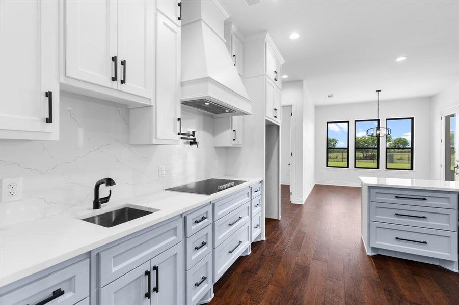 Kitchen featuring premium range hood, black electric stovetop, recessed lighting, backsplash, and dark wood-type flooring Kitchen featuring premium range hood, black electric stovetop, recessed lighting, backsplash, and dark wood-type flooring