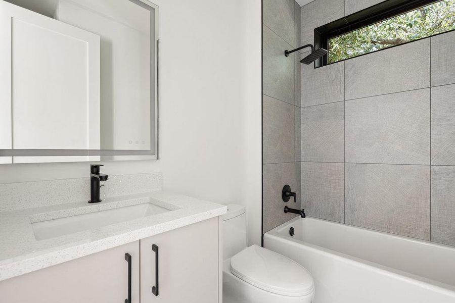 Full bath featuring vanity and washtub / shower combination