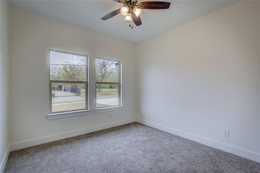 Carpeted spare room with baseboards and a ceiling fan Carpeted spare room with baseboards and a ceiling fan