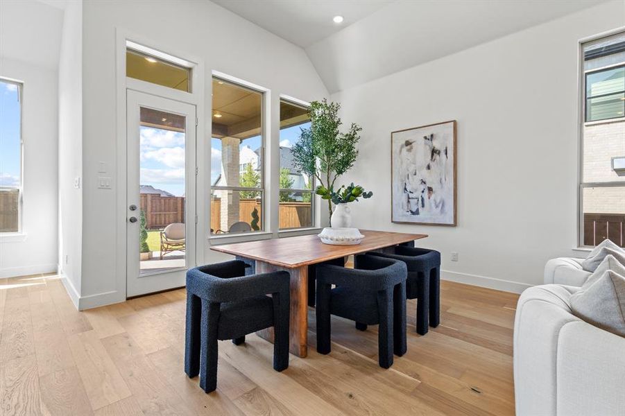 Dining area with light wood-style flooring, recessed lighting, and lofted ceiling