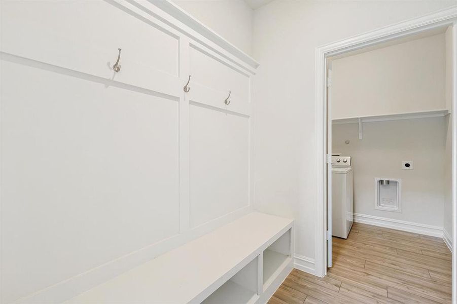 Mudroom featuring light wood-type flooring and washer / clothes dryer