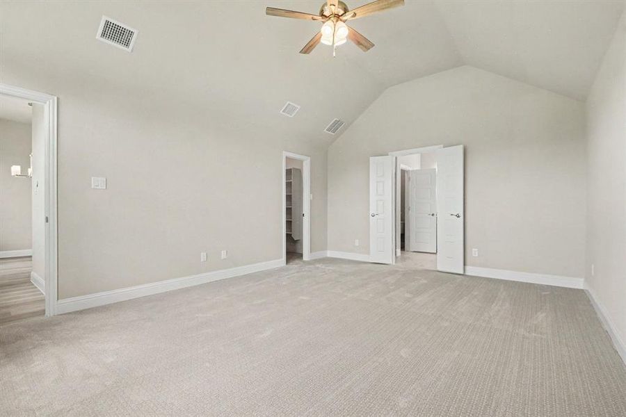 Expansive room with vaulted ceiling and light-toned carpeting Expansive room with vaulted ceiling and light-toned carpeting