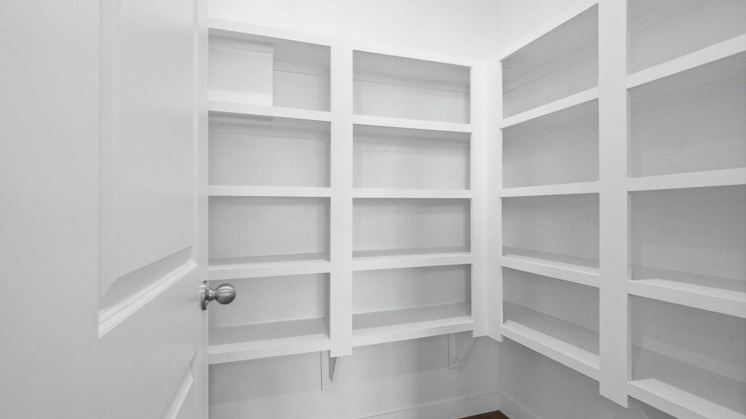 A laundry room featuring a washer and dryer, neatly arranged with ample space for laundry tasks and storage.