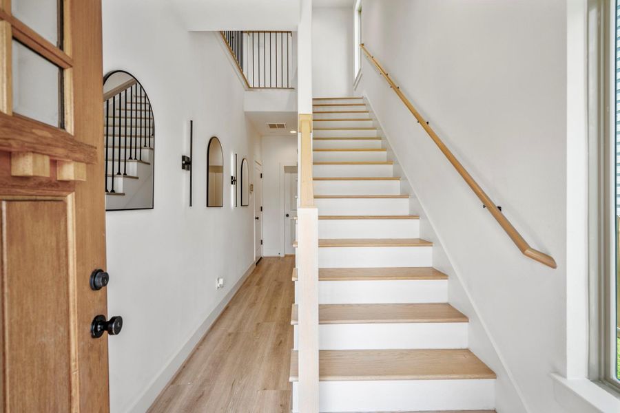 As you enter, you’re greeted by stunning engineered white-oak hardwood floors that flow seamlessly throughout the home, setting a warm and sophisticated tone.