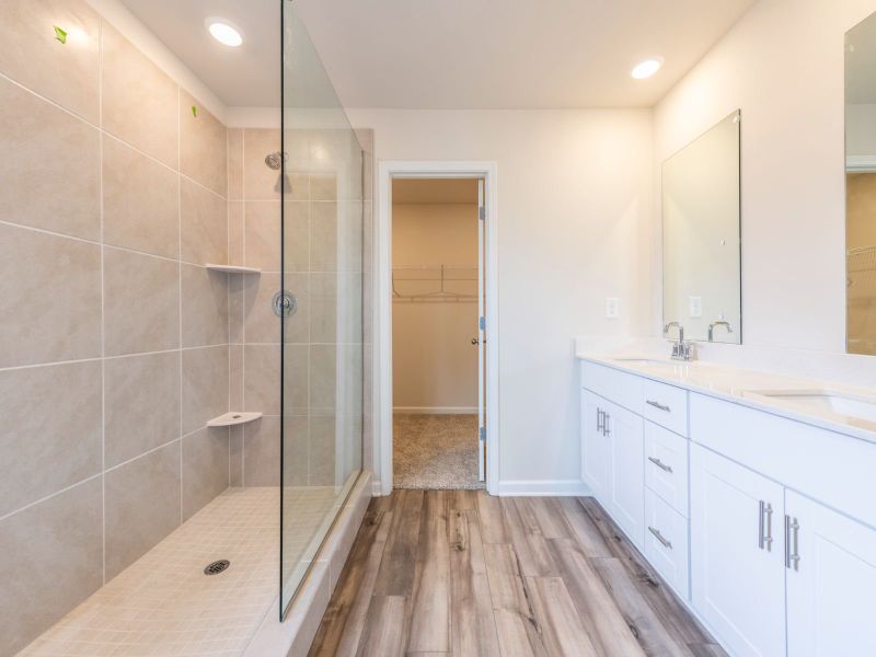 An ensuite bathroom features a walk-in shower and spacious closet.