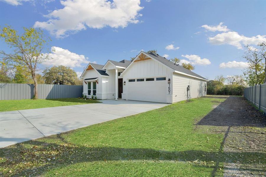 Modern farmhouse style home featuring board and batten siding, driveway, a shingled roof, and a garage