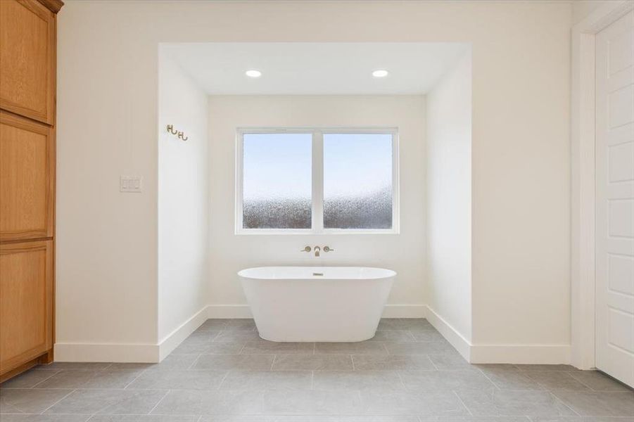 Full bath with a freestanding bath and recessed lighting