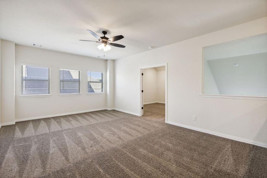 Carpeted empty room featuring ceiling fan