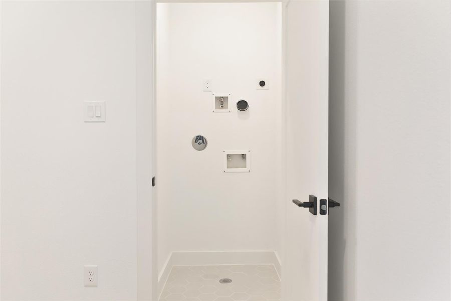 The hallway leads to a laundry room adorned with striking mosaic tile accents, adding a stylish and sophisticated touch. Located on the third floor. The hallway leads to a laundry room adorned with striking mosaic tile accents, adding a stylish and sophisticated touch. Located on the third floor.