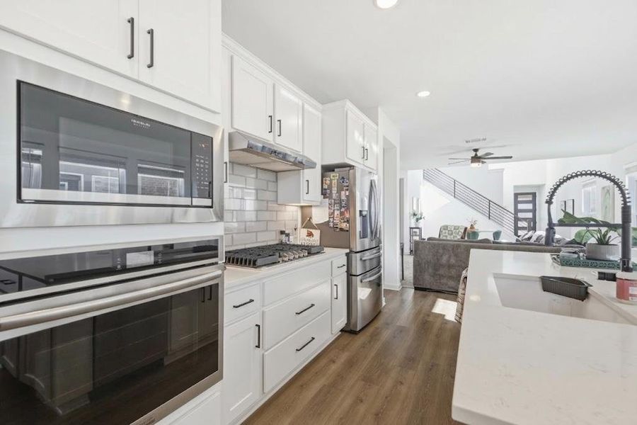 Gleaming stainless steel appliances and ample cabinetry define this contemporary culinary space.