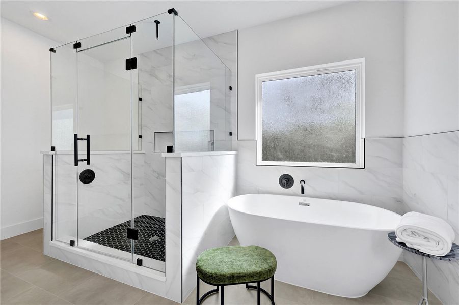full bath featuring a soaking tub and modern tile surround.