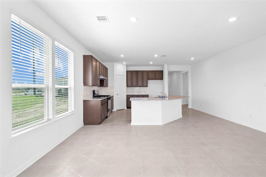 Start your day with a warm cup of coffee and quality time in this charming dining area! Highlights include large windows with blinds, custom neutral paint, ceramic tile flooring, recessed lighting, and high ceilings.
