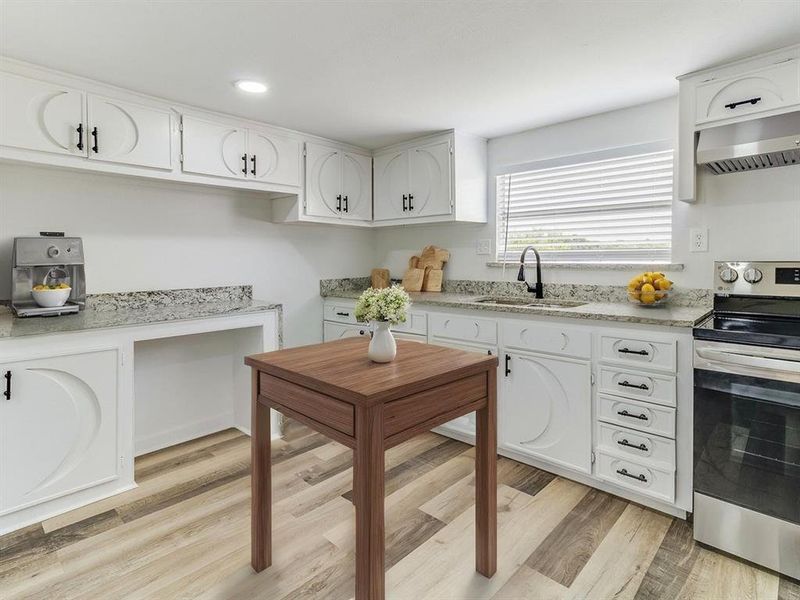 Virtually Staged Kitchen with stainless steel range with electric cooktop, exhaust hood, white cabinetry, light wood-style floors, and recessed lighting Virtually Staged Kitchen with stainless steel range with electric cooktop, exhaust hood, white cabinetry, light wood-style floors, and recessed lighting
