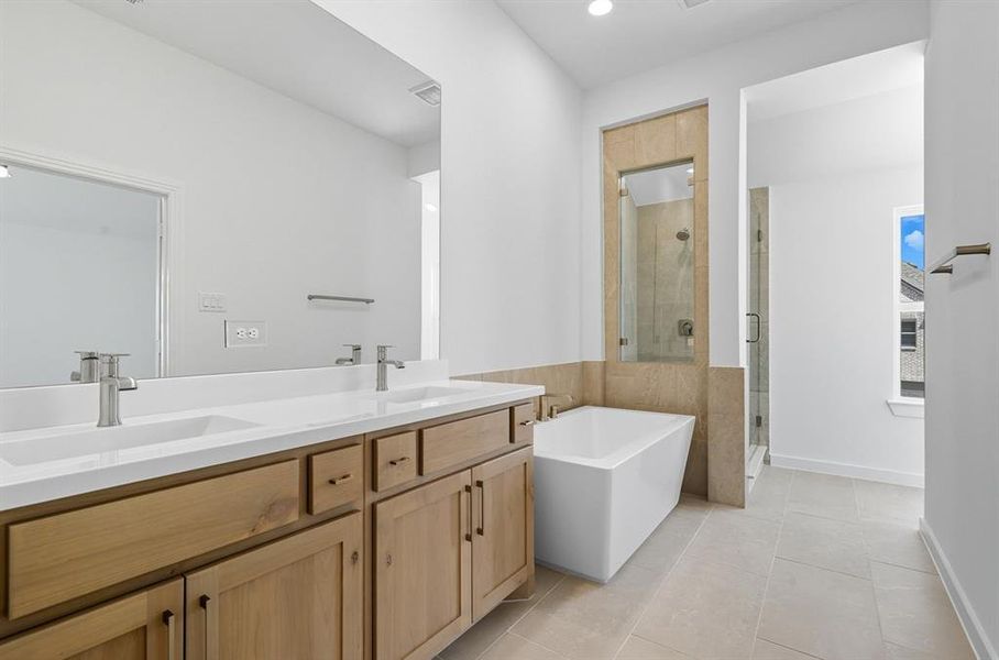 Full bath with a stall shower, a soaking tub, double vanity, light tile patterned floors, and recessed lighting Full bath with a stall shower, a soaking tub, double vanity, light tile patterned floors, and recessed lighting