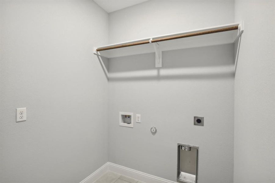 Washroom with tile patterned flooring, hookup for a washing machine, electric dryer hookup, and hookup for a gas dryer