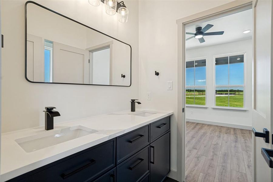 Dual vanity in jack and jill en-suite bathroom with matte black fixtures and dark cabinetry. Connects the two secondary bedrooms