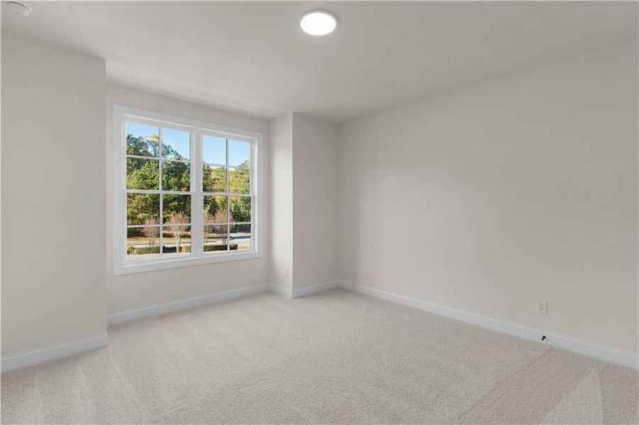 Spare room featuring light carpet and baseboards
