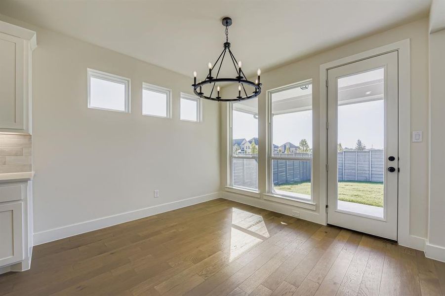 Unfurnished dining area featuring dark wood-style floors and a chandelier