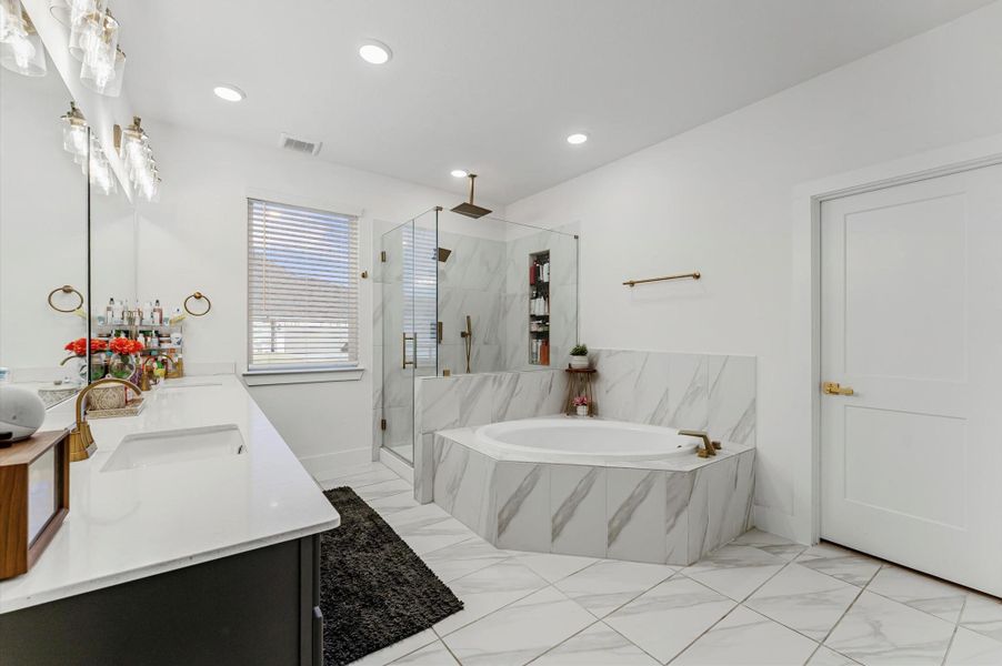 Remodeled Primary Bath with soaking tub, separate 5/8" frameless rain shower w/bench and gold hardware!