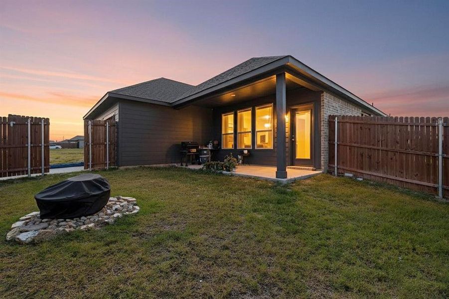 Back of property featuring a fenced backyard, a patio, a shingled roof, and brick siding Back of property featuring a fenced backyard, a patio, a shingled roof, and brick siding