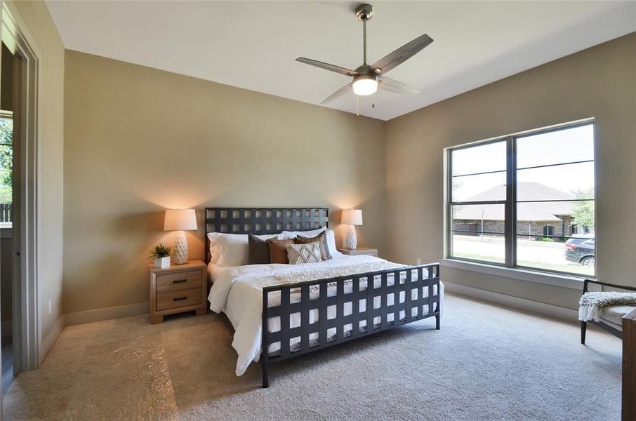 Bedroom with carpet floors, multiple windows, and a ceiling fan Bedroom with carpet floors, multiple windows, and a ceiling fan