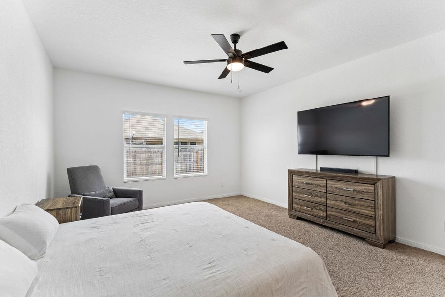 A well-lit primary bedroom offering a cozy retreat with ample space.