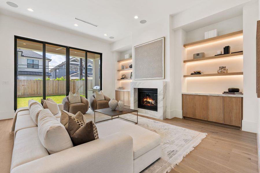 The living room opens beautifully to the outdoors through oversized sliding doors, filling the space with natural light and creating a seamless indoor-outdoor connection to the covered patio and backyard.