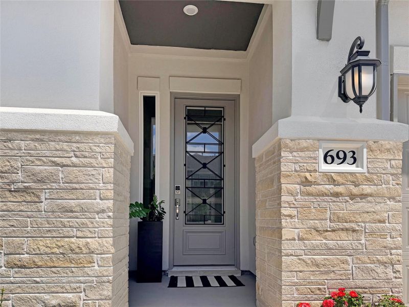 Doorway to property featuring stone siding and stucco siding